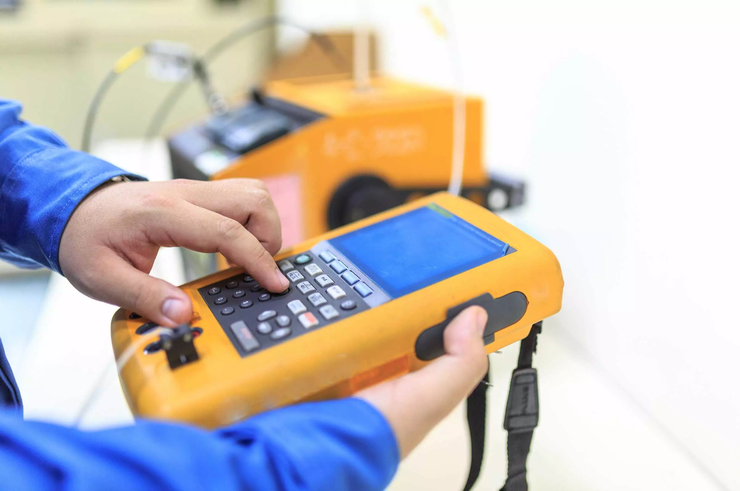 Hand holding calibration thermocouple and pressing buttons with other hand