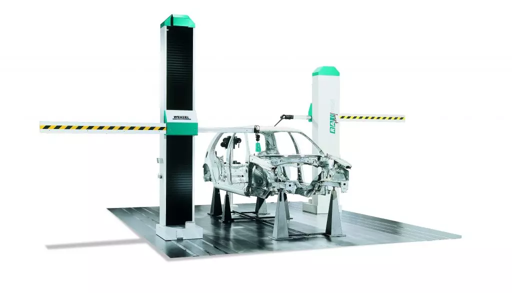 RA Plus WENZEL CMM RA Plus WENZEL CMM with two large pillars holding horizontal arms with a car frame on the flat, black base.