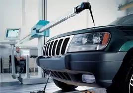 CMM Working on Car A CMM horizontal arm reaching over a black SUV front hood.