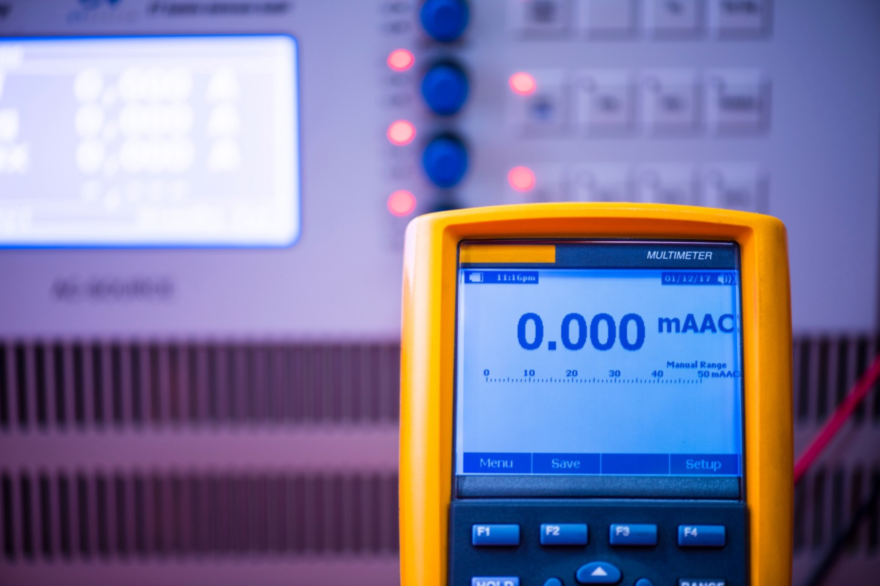 A digital multimeter displays zero current measurement in a lab setup, emphasizing electrical precision.